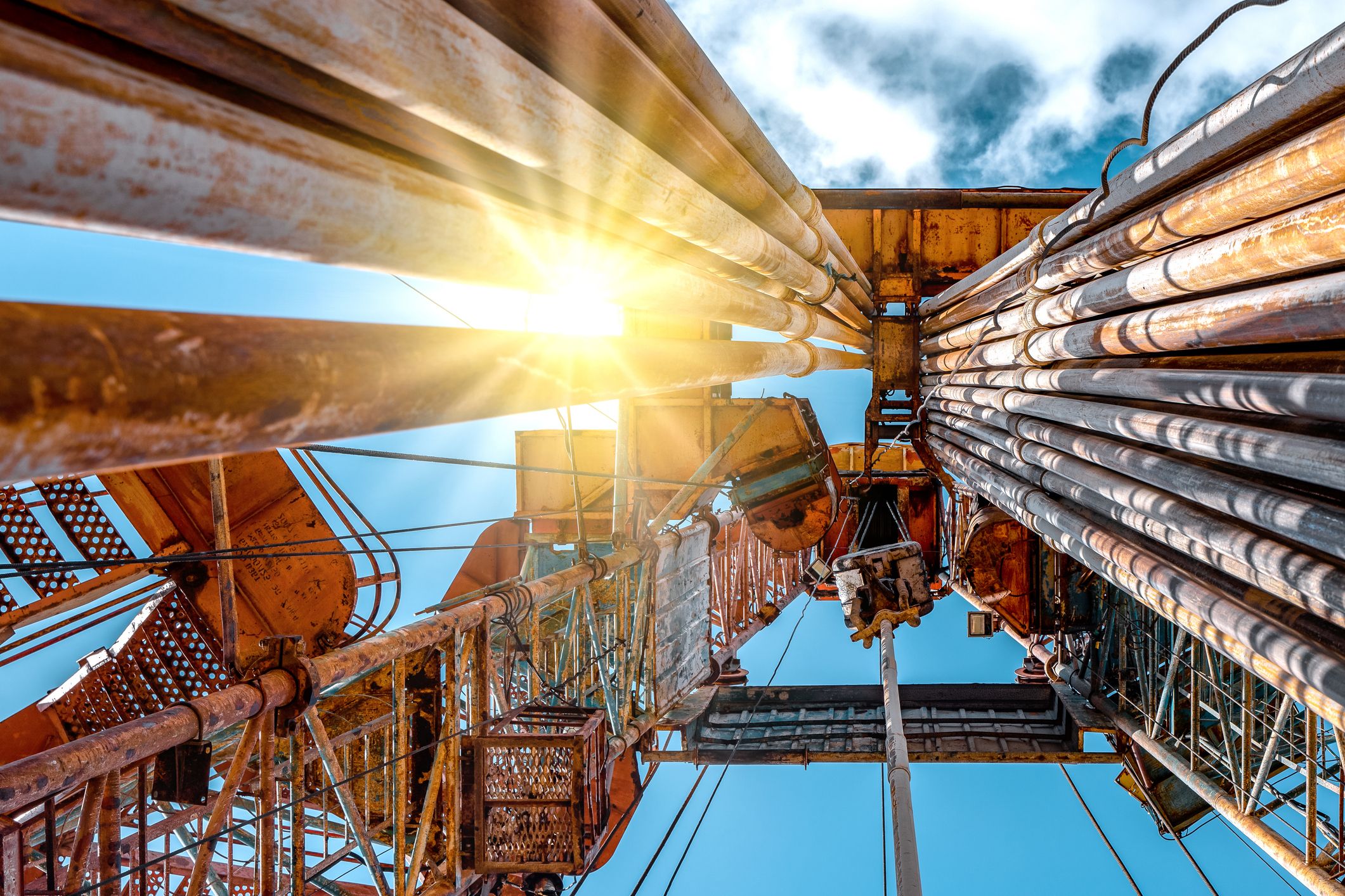 Oil and Gas Drilling Rig onshore dessert with dramatic cloudscape. Oil drilling rig operation on the oil platform in oil and gas industry.