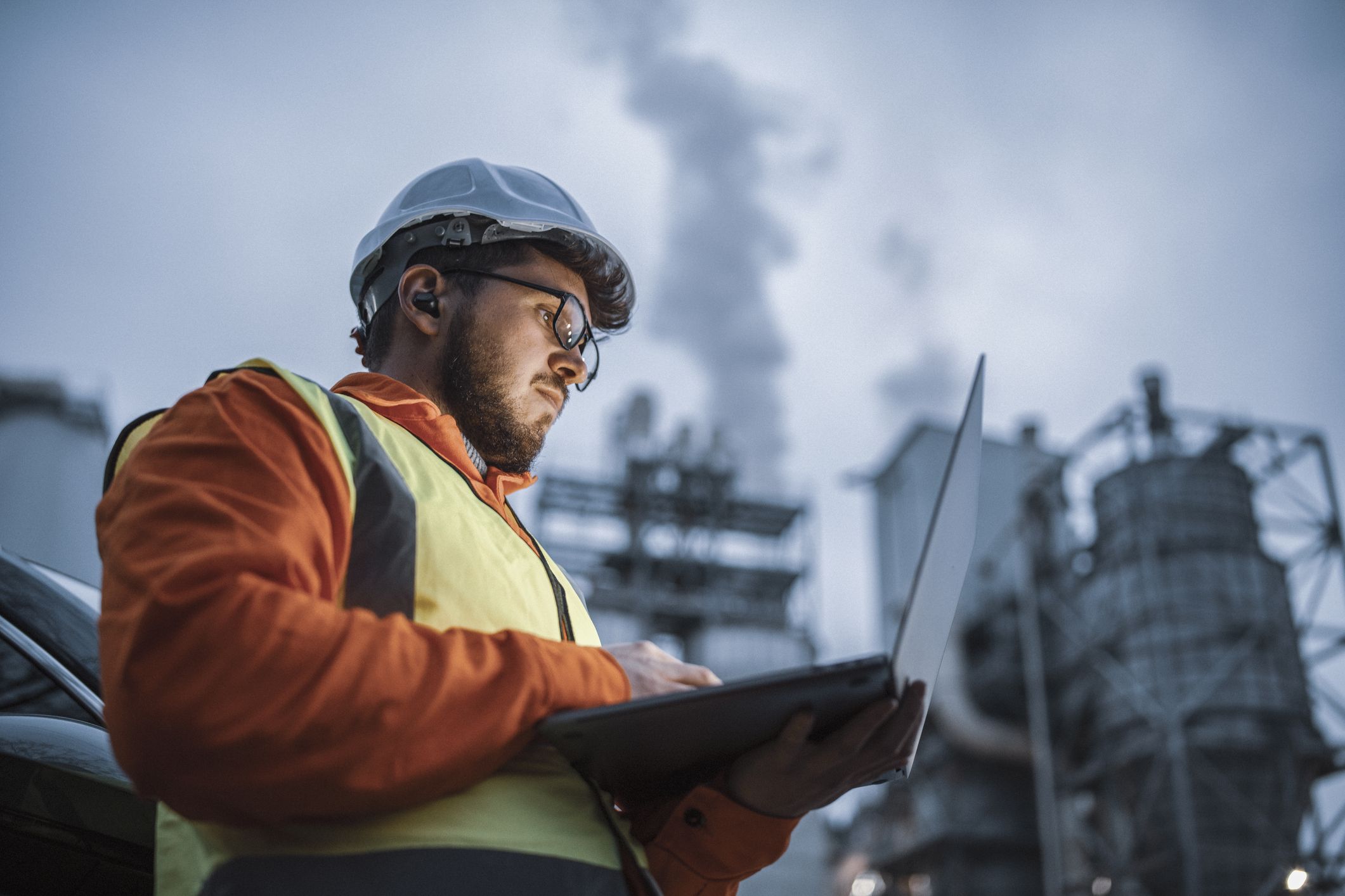 Serious handsome engineer using a laptop while working in the oil and gas industry.